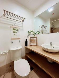 uma casa de banho com um WC branco e um lavatório. em Condo in Tagaytay City - SMDC Cool Suites - TRP15 em Tagaytay