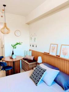 ein Schlafzimmer mit einem Bett, einem Tisch und einem Stuhl in der Unterkunft Condo in Tagaytay City - SMDC Cool Suites - TRP15 in Tagaytay