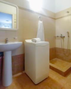 La salle de bains est pourvue d'un lavabo et d'une douche. dans l'établissement Derveni Seaside Apartments "Groundfloor", à Derveni