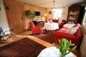 uma sala de estar com cadeiras vermelhas e uma mesa em Ferienhaus Spreewaldnostalgie em Burg