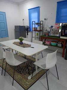 uma mesa branca e cadeiras num quarto em D'RinduVillage Homestay em Marang