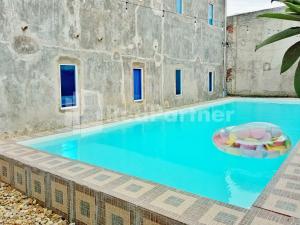 ein großer Pool in einem Gebäude mit blauem Wasser in der Unterkunft Cerry Village near RS Mitra Siaga Tegal RedPartner in Tegal