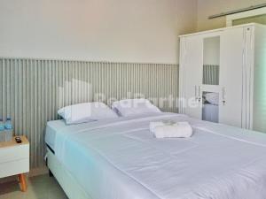 ein großes weißes Bett mit weißen Handtüchern darauf in der Unterkunft Cerry Village near RS Mitra Siaga Tegal RedPartner in Tegal