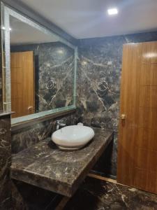 a bathroom with a sink and a mirror at Hotel Benzz Park Chennai in Chennai