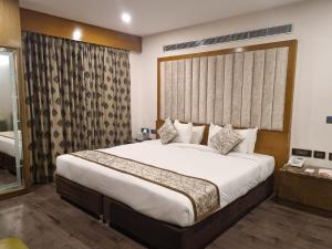 a bedroom with a large bed and a large window at Hotel Benzz Park Chennai in Chennai