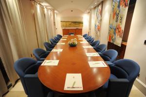 a long conference table in a room with blue chairs at Grand Hotel Ortigia in Siracusa
