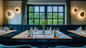 a long table in a restaurant with a window at Landhotel Zur Eiche in Buxtehude