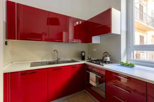 a kitchen with red cabinets and a sink at ROMAC Mazzini with 5 bedrooms near the Vatican in Rome