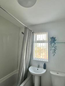 een badkamer met een wastafel, een toilet en een raam bij Howard’s House, Home from Home in Thornaby on Tees