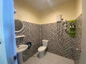 a bathroom with a toilet and a sink at Suntalee House in Nai Yang Beach