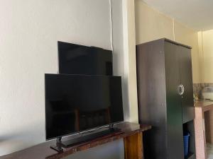 TV de pantalla plana grande en la pared en Suntalee House, en Nai Yang Beach
