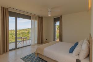 a bedroom with a bed and a large window at Messinian Nest in Gialova
