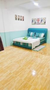 een bed in een kamer met een houten vloer bij Kakmas Homestay in Papar