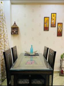 a dining room table with a blue vase on it at Aquila Home 2 BHK South Delhi Near Ashram Metro in New Delhi