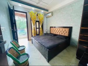 a bedroom with a large bed and two chairs at Aquila Home 2 BHK South Delhi Near Ashram Metro in New Delhi