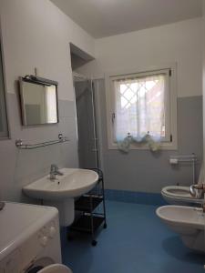 a bathroom with two sinks and a mirror and two toilets at Casetta gialla in Pieve di Cadore