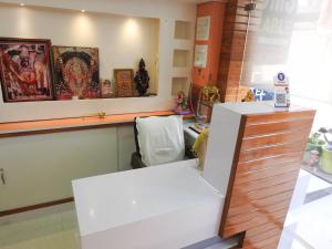 a kitchen with a white counter and some items on the wall at Hotel Shri Sai Darshan in Shirdi