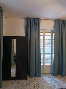 a room with blue curtains and a mirror at B&B Napoli Fuorigrotta in Naples