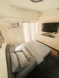 - une petite chambre avec un lit et une fenêtre dans l'établissement Serenity Heights 41st by Celandine Condo, à Manille