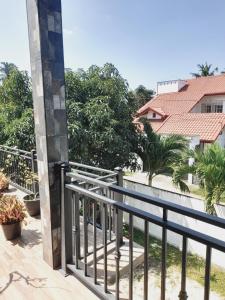 d'un balcon avec une balustrade noire et des arbres. dans l'établissement Moon Deck Villa, à Katunayake