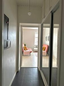 a hallway with a room with a couch and a mirror at Cute loft by Tram Stop in Helsinki