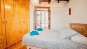 Un dormitorio con una cama con toallas azules. en PRECIOSO DúPLEX PLAZA NUEVA, en Granada 3 fotos más