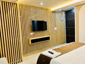 a hotel room with a television on a wooden wall at The Cozy Cool Cabin in Dehradun