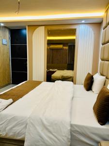 デヘラードゥーンにあるThe Cozy Cool Cabinのベッドが2つと鏡があるホテルの部屋