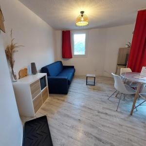 a living room with a blue couch and a table at Le Studio du Queyras avec vue sur la montagne in Abriès