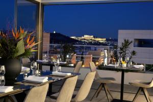 una mesa y sillas en un balcón con vistas en Athenaeum Smart Hotel, en Atenas