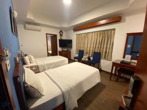 a hotel room with two beds and a desk at A25 Hotel - 221 Bạch Mai in Hanoi