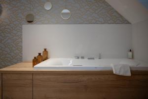 Cette chambre comprend une salle de bains pourvue d'une grande baignoire. dans l'établissement Les Cotonnades Lorient, à Lorient