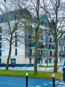 a group of trees in front of a building at Skyview Luxury appartement à Montevrain in Montévrain