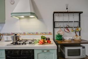 a kitchen with a stove and a sink with fruits and vegetables at Dogliani Borgo Castello - Happy Rentals in Dogliani