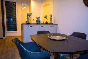 a dining room with a table and blue chairs at Skyview Luxury appartement à Montevrain in Montévrain