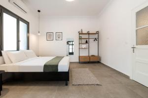 ein weißes Schlafzimmer mit einem Bett und einem Fenster in der Unterkunft Ranny House in Athen
