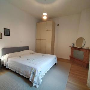 a bedroom with a white bed and a cabinet at Mamè Guest House in Figlino