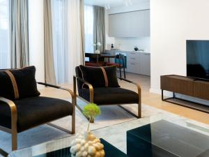 uma sala de estar com duas cadeiras e uma televisão em Holistic Skin & Wellness SPA Apartments em Birstonas