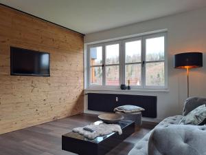 a living room with a couch and a tv on a wall at L-Elf in Hauzenberg