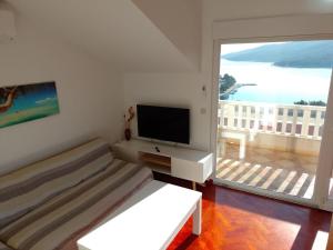 sala de estar con cama, TV y balcón en Apartments Silvije, en Marina