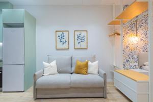 a living room with a couch with yellow pillows at FLORIT FLATS - The Sorolla Apartments in Valencia