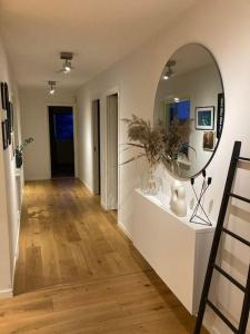 un pasillo con un espejo en una pared blanca en Topp modern Villa 200m från havet nära centrum och natur, en Stenungsund