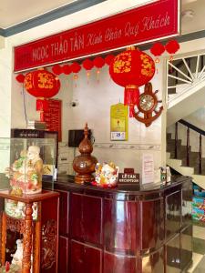 licznik z czerwonymi latarniami i zegarem w obiekcie NGỌC THẢO TÂN Motel w mieście Ấp Châu Thới