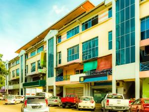 a parking lot with cars parked in front of a building at Sutera Inn Inanam in Kota Kinabalu