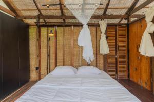 um quarto com uma grande cama branca num quarto em Calidas Hill em Kintamani