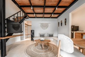 a living room with a wooden ceiling and a table at Sarang Apartments by EVDEkimi in Ubud