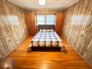 um quarto com uma cama num quarto com pisos em madeira em Cozy Philly Haven: Ideal Home em Filadélfia