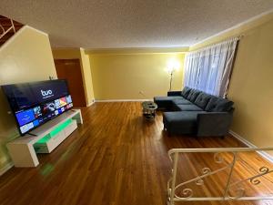uma sala de estar com um sofá e uma televisão de ecrã plano em Cozy Philly Haven: Ideal Home em Filadélfia
