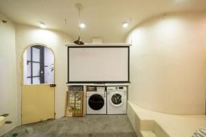 einen großen Bildschirm in einem Zimmer mit Waschmaschine in der Unterkunft Shanghai Hills & Well-time Homestay in Shanghai