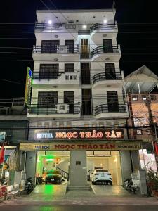 ein hohes weißes Gebäude mit davor geparkt in der Unterkunft NGỌC THẢO TÂN Motel in Ấp Châu Thới